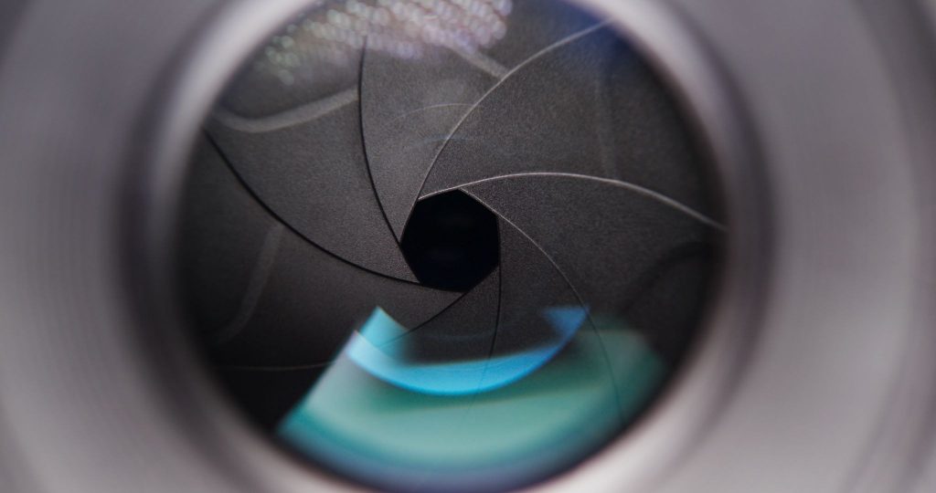 A close-up of adjusting the aperture on the camera lens