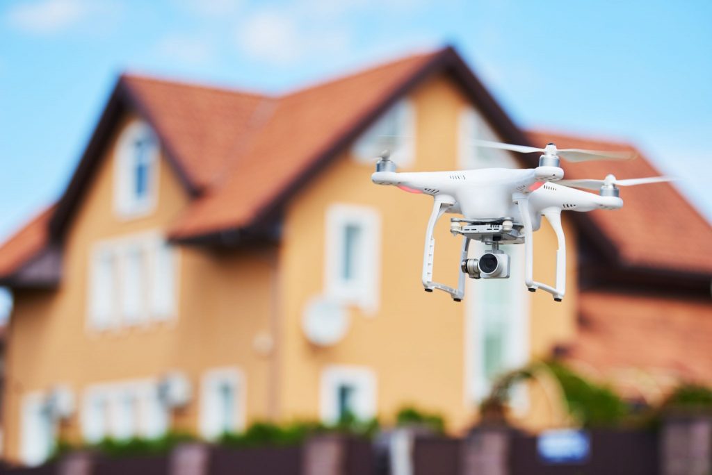A photography drone flying in front of a house