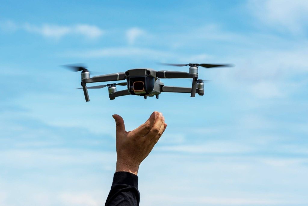 A close-up on a photographer’s hand releasing a drone